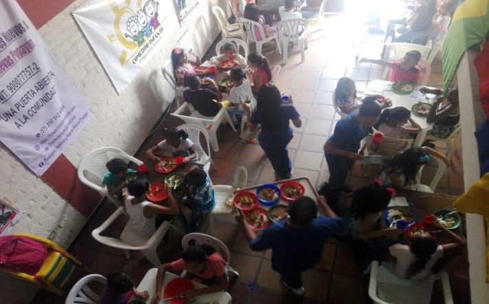 Niñas y niños compartiendo en las mesas del comedor